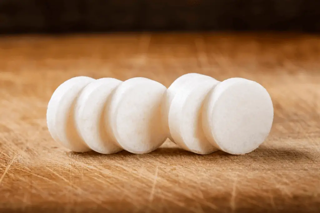 6 circular hard candies on a cutting board.