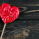 Red, heart-shaped lollipop on a table