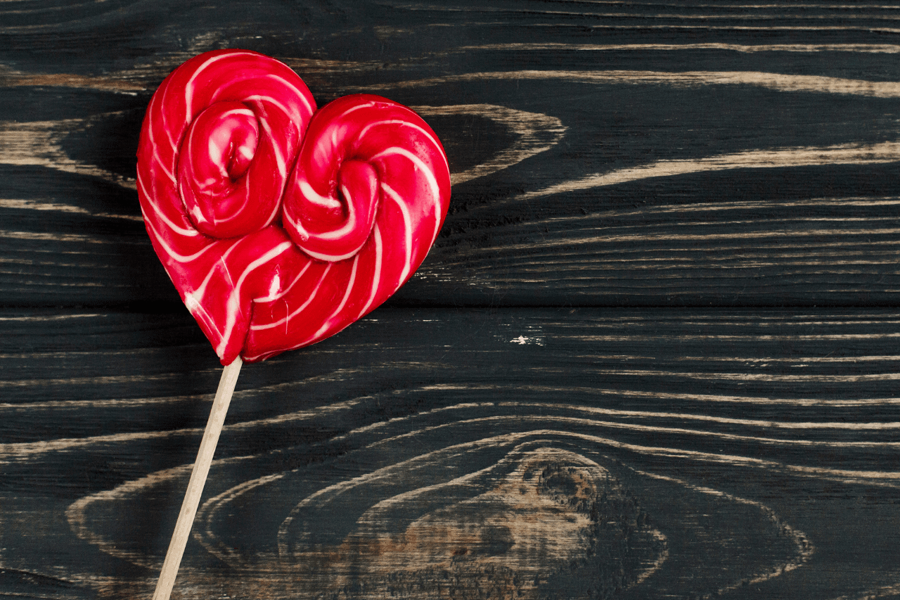 Red, heart-shaped lollipop on a table