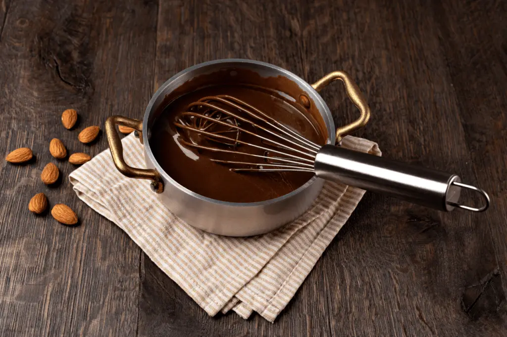 Thinning chocolate with coconut oil in a pot.